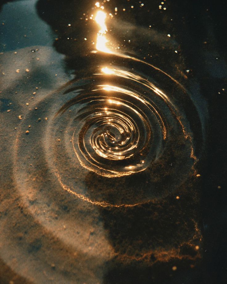 Golden light spiraling across dark water